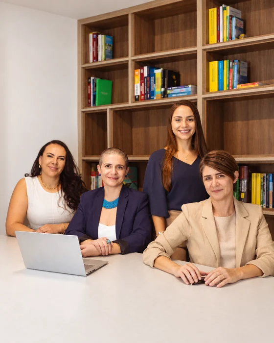 Equipe do escritório Campos Marque Morita & Goularte em frente à estante de livros